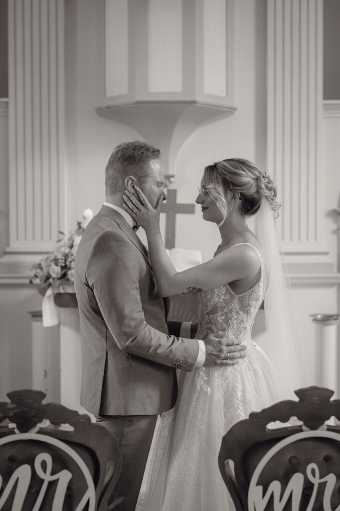 Brautpaar steht alleine in Kirche und schaut sich dabei romantisch an .
